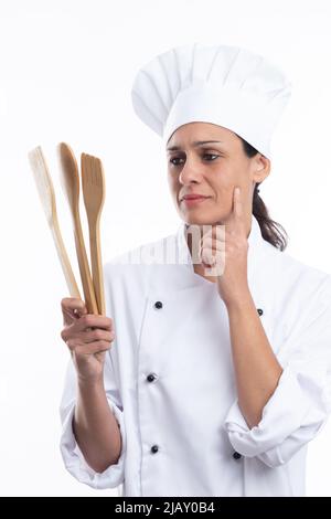 Portrait of young caucasian chef thinking what dish she will make now on white background. Vertical format. Stock Photo