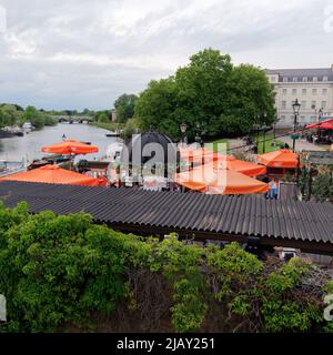 Richmond, Greater London, England, May 18 2022: View along the River Thames from the bridge over Richmond Road including an outdoor bar with parasols. Stock Photo