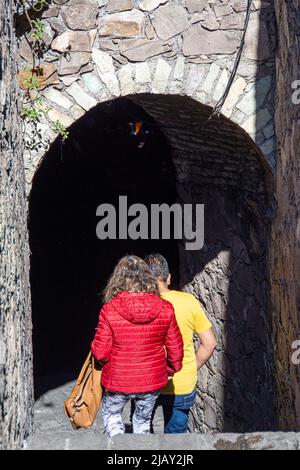 A couple enters one of the city's many underground tunnels that can be found underground throughout the municipality, Guanajuato, Guanajuato, Mexico. Stock Photo