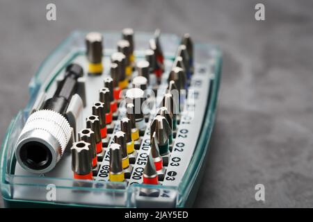 A set of metal power bits in a box on a gray background, for repair and maintenance Stock Photo