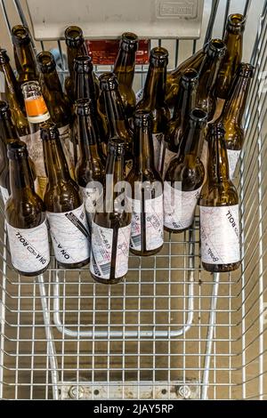 A metal shopping basket is filled here to the brim with bottles of the beer "On A Roll", their labels wrapped in coloured yarn; the beer is Lady Brewery's 2022 Design March edition from Reykjavik, Iceland, created in collaboration with the duo Gæla. Stock Photo