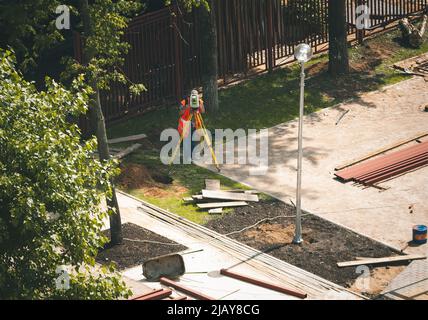 young engineer use the Total Station (tacheometer, theodolite) at urban landscaping design Stock Photo