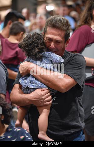 Uvalde Texas USA, May 25 2022: A man hugs a small child during a Uvalde, Texas community-wide service of healing after a lone gunman entered Robb Elementary School the day before and killed 19 children and two teachers. ©Bob Daemmrich Stock Photo