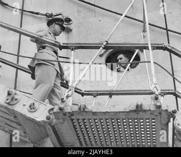 As the Duke of Gloucester comes down the gangway to his barge in Sydney harbour, he poses for a photograph taken by a member of the crew of the ship. January 29, 1945. Stock Photo
