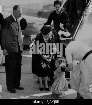 Queen Mother, Princess Fly In Comet -- The Queen Mother - Princess Margaret is seen coming down the steps from the aircraft accepting a nosegay from Anne De Haviiland, granddaughter of Sir Geoffrey De Havilland on her return to Hatfield after the flight. Anne, having trouble with her curtsey, is assisted by her mother, Mrs. Peter De Havilland. On left is Mr. W.E. Nixon, Managing Director of the De Havilland Company. The Queen Mother and Princess Margaret flew over the continetnt in a comet jet airliner of E.O.A.C. to-day (Friday). May 23, 1952. (Photo by Reuterphoto). Stock Photo