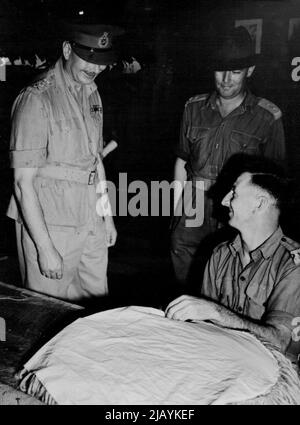 Duke of Gloucester visits convalescent Depot at Lae, where front-line soldiers recuperate - The Duke pauses to chat with LAC H. A. Rayner (Lithgow, NSW), who is making a floor-mat at the depot. July 09, 1945. Stock Photo