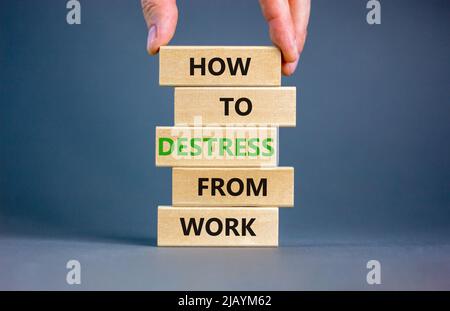 Destress from work symbol. Concept words How to destress from work on wooden blocks. Doctor hand. Beautiful grey background. Psychological business an Stock Photo
