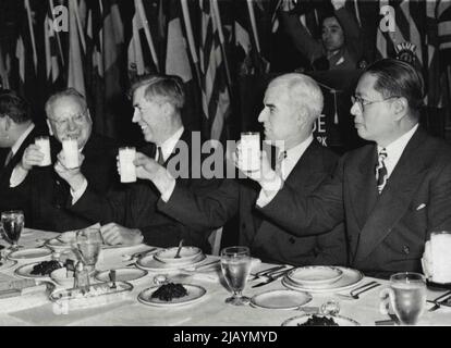 Diplomats, officials toast Lend-Lease -- Drinking a toast at the luncheon in Washington, March 11, in observance of the second anniversary of lend-lease operations are (left to right): Maxim Litvinoff, Soviet Ambassador; Vice President Henry A. Wallage; Lend-Lease Administrator E.R. Stettinius, Jr., and T.V. Soong, Chinese foreign minister. The beverage is milk reconstituted from dry whole milk such as is used in Lend-Lease shipments to conserve cargo space. November 03, 1943. (Photo by Associated Press Photo). Stock Photo