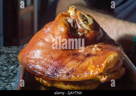 Roasted pork knuckle eisbein with cabbage and mustard on wooden cutting board. Stock Photo