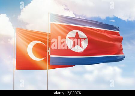 Sunny blue sky and flags of north korea and turkey Stock Photo