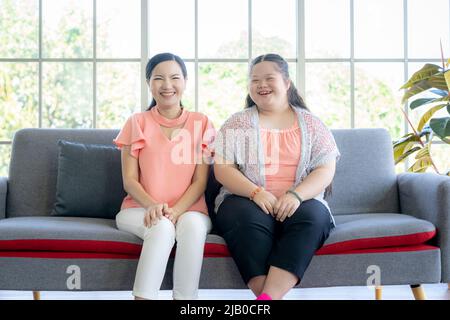Asian person with Down syndrome with mom having fun together at living room Stock Photo