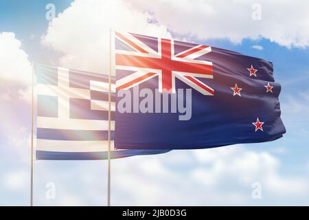 Sunny blue sky and flags of new zealand and greece Stock Photo