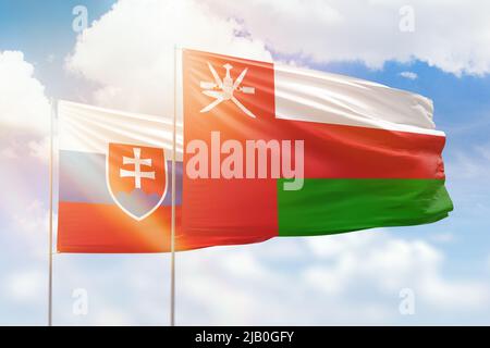 Sunny blue sky and flags of oman and slovakia Stock Photo