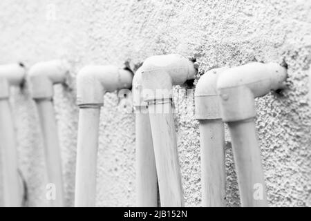 White plastic pipe corners in a row, close up photo with selective focus Stock Photo