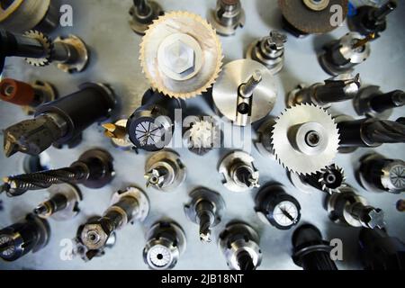 High angle view of metal milling cutters with various bits on steel table Stock Photo