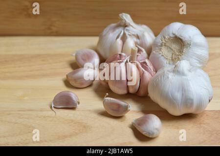 Garlic bulbs on wood background, close-up. Organic garlic top view. Food background. Selective focus. Concept of spices for healthy cooking. Stock Photo