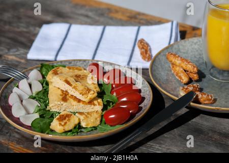 A light breakfast of French omelet with radishes, spinach tomatoes and arugula. European Breakfast Stock Photo