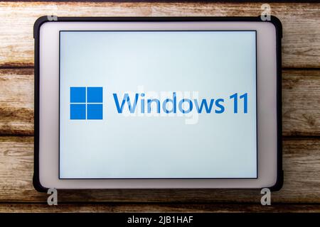 Kumamoto, JAPAN - Jun 25 2021 : Logo of Microsoft Windows 11 on tablet on shabby chic table. Win 11 is a major release of the Windows NT OS Stock Photo