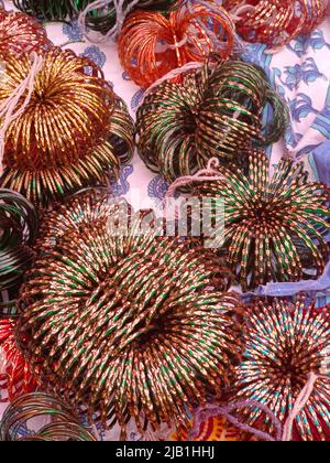 Pre wedding ceremony a lady bangle seller is putting green glass bangles, Indian culture. Stock Photo