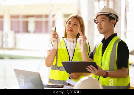 Female inspectors discussing with head engineer about construction project Stock Photo