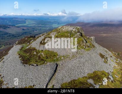 Aerial photograph of the distinctive granite plug and hillfort remains on the Mither Tap on top of the mountain of Bennachie, Aberdeenshire, Scotland Stock Photo