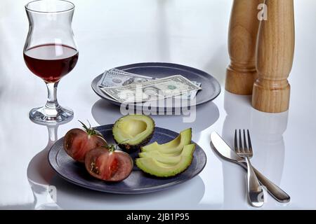 Plate with dollars and a plate of food on a white served table. Restaurant tip concept Stock Photo