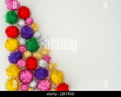 tinsel colored fluffy pom pom balls on a white background Stock Photo