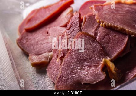 The Slices of Smoked Beef Tongues in the pack in the plastic pack sold by local supermarket in Japan on the table. Stock Photo