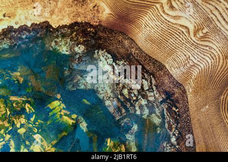 natural stones filled with epoxy resin in a wooden countertop. Handmade designer furniture. Stock Photo