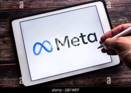 Kumamoto, JAPAN - Oct 29 2021 : Logo of US technology conglomerate Meta Platforms, Inc. (formerly known as Facebook) on tablet. Man hand holding a pen Stock Photo