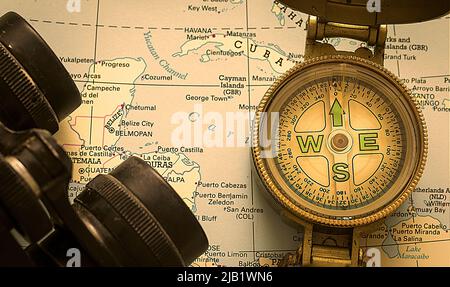 Compass. Old hand held compass on map with binoculars. Flat Lay.Focus in the centre.Stock Image. Stock Photo