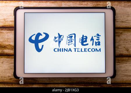 Kumamoto, JAPAN - Nov 6 2021 : Closeup logo of China Telecom, a Chinese state-owned telecommunication company, on tablet on shabby chic wooden table Stock Photo