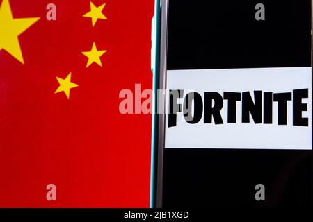 Kumamoto, JAPAN - Nov 9 2021 : Conceptual closeup logo of Fortnite, online video game developed by Epic Games, on iPhone on Chinese flag bg Stock Photo