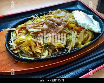 Japanese fried noodle Yakisoba with medamayaki (fried egg) plate. Yakisoba is a frying ramen-style wheat noodles with bite-sized porks & vegetables Stock Photo