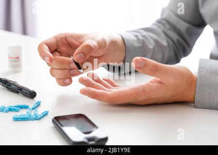 Man Using Glucometer Man using glucometer. Diabetes kit. Blood glucose level measure Stock ...