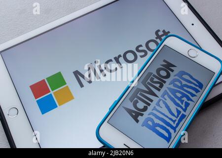 Microsoft and Activision Blizzard logos on smartphone and tablet. Microsoft announced that they are planning to purchase Activision-Blizzard Stock Photo