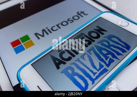 Microsoft and Activision Blizzard logos on smartphone and tablet. Microsoft announced that they are planning to purchase Activision-Blizzard Stock Photo