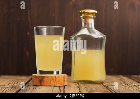 Russian cold rye beverage Kvass in glass and bottle on wooden table horizontal Stock Photo