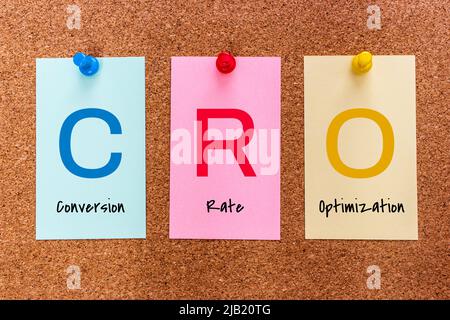 Conceptual 3 letters keyword CRO (Conversion Rate Optimization) on multicolored stickers attached to a cork board. Stock Photo