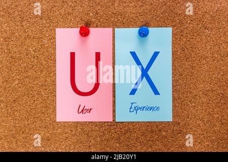 Conceptual 2 letters keyword UX (User Experience) on multicolored stickers attached to a cork board. Stock Photo