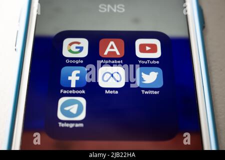 Popular SNS or IT company icons (Google, Alphabet inc., YouTube, Facebook, Meta Platform, Twitter and Telegram) with Russian flag bg on an iPhone. Stock Photo