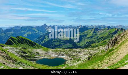 Impressive view to the Allgäu Alps on a summer morning with Laufbichlsee in foreground Stock Photo