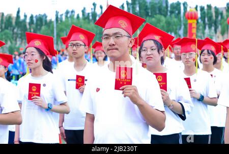 ZHANGYE, CHINA - JUNE 2, 2022 - More than 1,470 18-year-old high school seniors receive the Constitution of the People's Republic of China and adult g Stock Photo