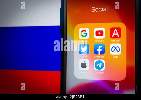 Popular SNS & IT brands (Google, Alphabet inc., YouTube, Facebook, Meta Platform, Twitter, Apple & Telegram) on iPhone with Russian flag in dark mood Stock Photo