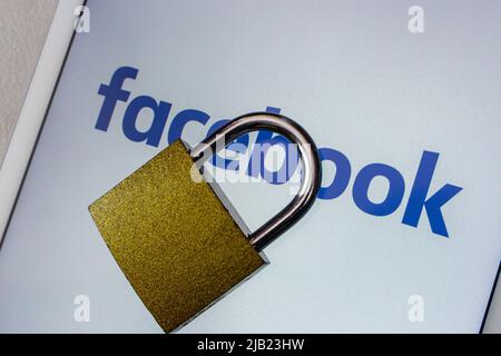 Kumamoto, JAPAN - Feb 22 2022 : Facebook logo with big padlock on the tablet. Digital security in the social media account concept. Stock Photo