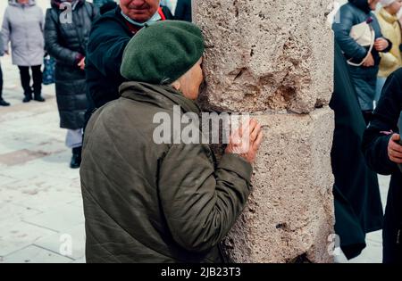Bolgar, Tatarstan, Russia. May 21, 2022. Muslims touch the sacred pillar. The stone pillar around which the ritual circumambulation (Tawaf) is performed Stock Photo
