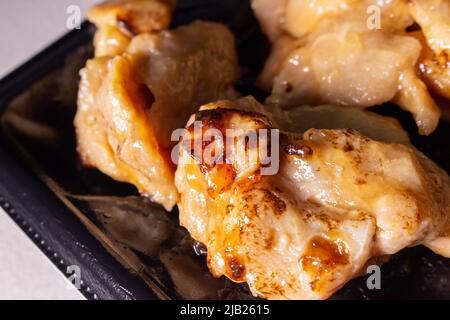 A takeout Japanese Teriyaki chicken in a container. Teriyaki is a cooking technique used in which foods are grilled with a soy sauce, mirin, and sugar Stock Photo