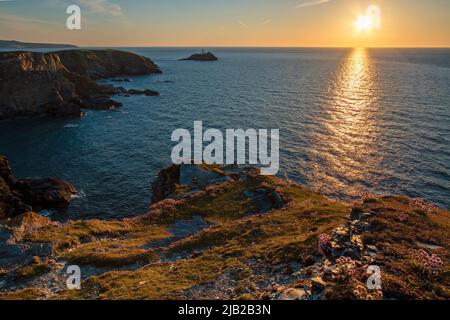 A sunset landscape of the Cornish Coast at The Knavocks looking across the high cliffs to Godrevy Lighthouse Stock Photo