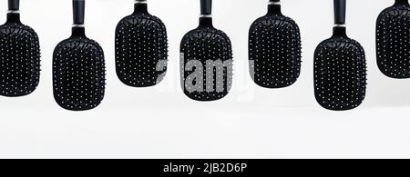 Brush, hair combs isolated on white concrete wall background, with shadows on the table. Creative banner for beauty salons, hairdressers or hair cosme Stock Photo