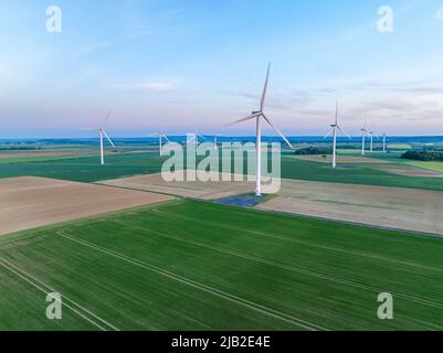 Aerial view of a countryside with agricultural fields and wind turbines. Environments for wind power, green and sustainable energy Stock Photo